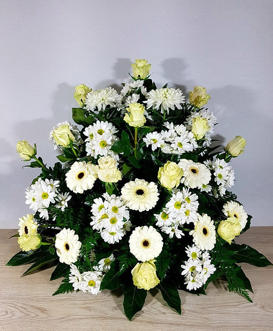 Centro de flores funerarias blancas como margaritas o gerberas