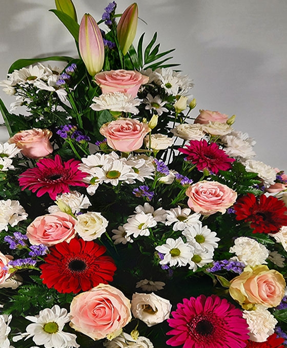 Centro de flores funerarias de color variado