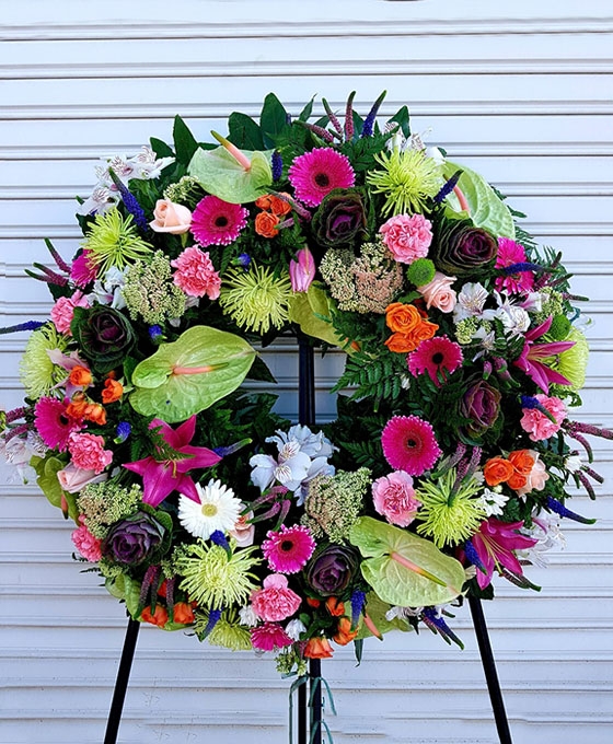 Corona de flores funerarias con colores variados